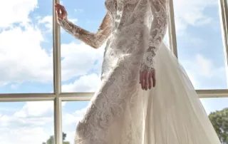 Robe de mariée Biennia – Raffinement romantique et manches longues en dentelle Laissez-vous séduire par l’élégance intemporelle de Biennia, une robe de mariée à manches longues conçue pour les mariées à la recherche d’un style à la fois royal et moderne. Avec sa silhouette sirène délicatement structurée et ses détails floraux brodés, Biennia incarne le romantisme à l’état pur. Le corsage, finement travaillé, présente un décolleté en cœur profond, soutenu par un jeu de transparence subtil et de dentelle illusion. Les manches longues en tulle brodé, légèrement bouffantes aux épaules, apportent une touche de grâce et de noblesse. La jupe sirène est magnifiée par une somptueuse surjupe en tulle brodée, qui ajoute volume et fluidité, tout en créant une traîne majestueuse ornée de motifs floraux raffinés. Biennia marie harmonieusement sensualité, romantisme et tradition pour une allure exceptionnelle.
